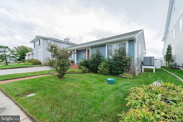 view of front of property with cooling unit and a front yard