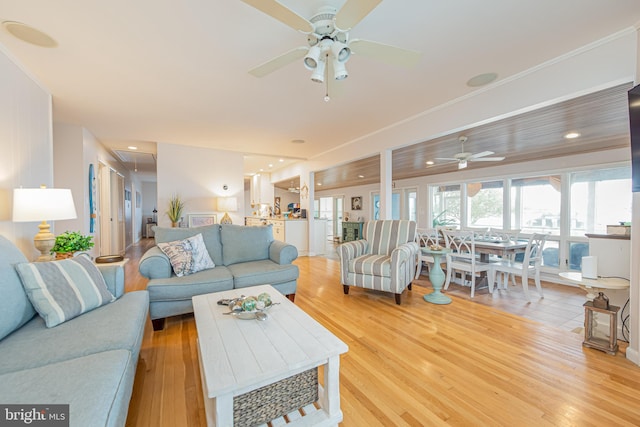 living room with ceiling fan, crown molding, and light hardwood / wood-style floors