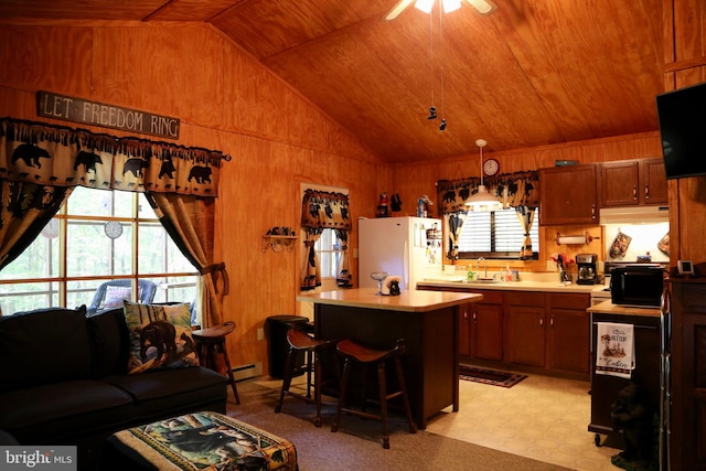 kitchen with a healthy amount of sunlight, white refrigerator, wooden ceiling, and a kitchen breakfast bar