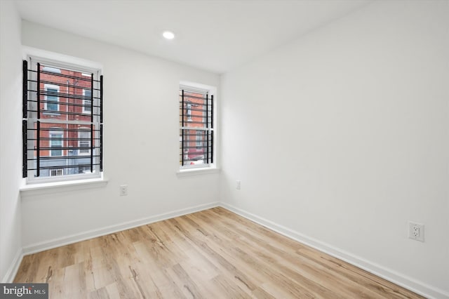 spare room featuring light wood-type flooring and a healthy amount of sunlight