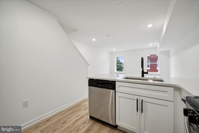 kitchen with light hardwood / wood-style floors, sink, white cabinetry, kitchen peninsula, and stainless steel appliances