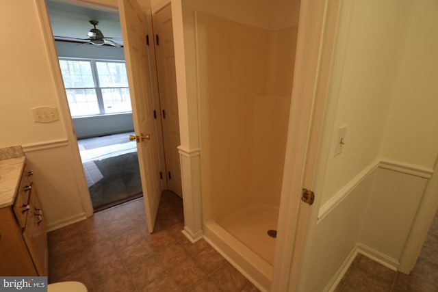 bathroom with walk in shower, vanity, and ceiling fan