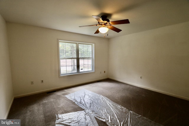 empty room featuring ceiling fan and carpet