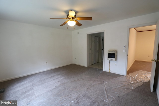 unfurnished bedroom featuring heating unit, ceiling fan, and carpet floors