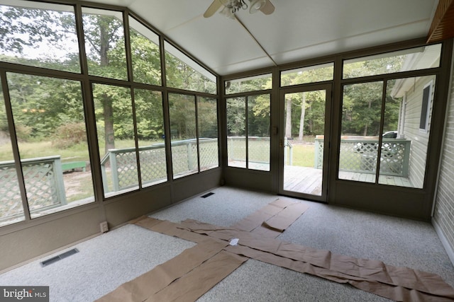 unfurnished sunroom featuring vaulted ceiling, ceiling fan, and a healthy amount of sunlight