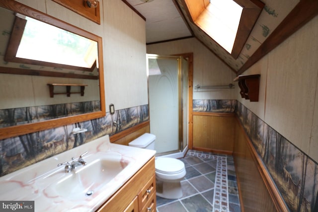 bathroom with vaulted ceiling with skylight, tile patterned flooring, a shower with shower door, vanity, and toilet