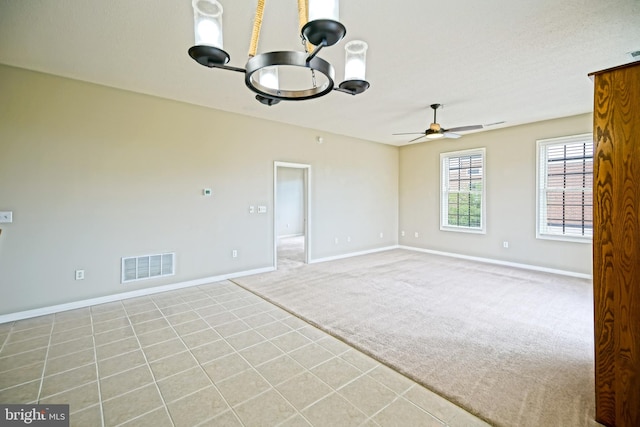 spare room with light tile patterned floors and ceiling fan with notable chandelier