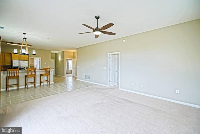 unfurnished living room featuring ceiling fan and light tile patterned floors