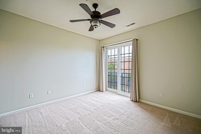 carpeted empty room with ceiling fan and a textured ceiling