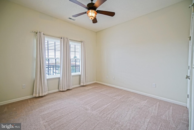 spare room featuring light colored carpet and ceiling fan