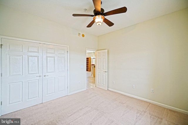 unfurnished bedroom with ceiling fan, a closet, and light carpet