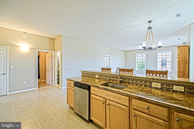 kitchen featuring pendant lighting, backsplash, sink, stainless steel dishwasher, and light tile patterned floors