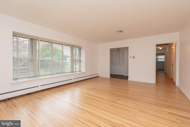 spare room with a baseboard radiator and light hardwood / wood-style flooring