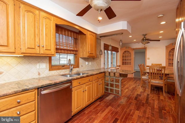 kitchen featuring tasteful backsplash, dark wood-type flooring, sink, light stone countertops, and appliances with stainless steel finishes