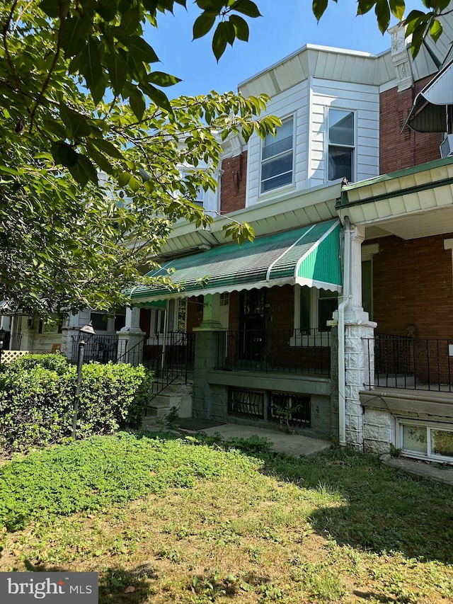 view of side of property with covered porch and a yard