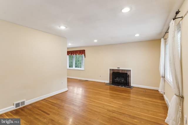 unfurnished living room with a fireplace and light hardwood / wood-style flooring