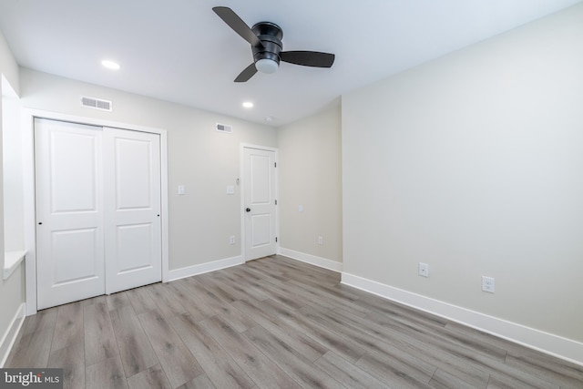 unfurnished bedroom with light hardwood / wood-style flooring, a closet, and ceiling fan