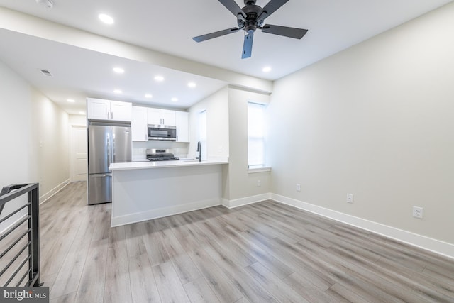 kitchen featuring white cabinetry, kitchen peninsula, light hardwood / wood-style flooring, appliances with stainless steel finishes, and ceiling fan