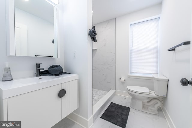 bathroom featuring a tile shower, vanity, and toilet