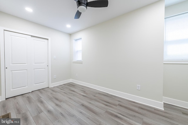 unfurnished bedroom featuring light hardwood / wood-style flooring, a closet, and ceiling fan