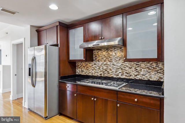 kitchen with under cabinet range hood, visible vents, decorative backsplash, stainless steel appliances, and light wood-type flooring