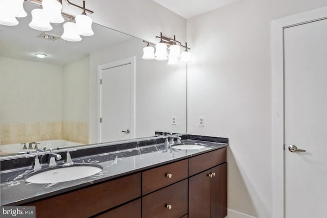 bathroom with a notable chandelier, double vanity, a tub to relax in, and a sink