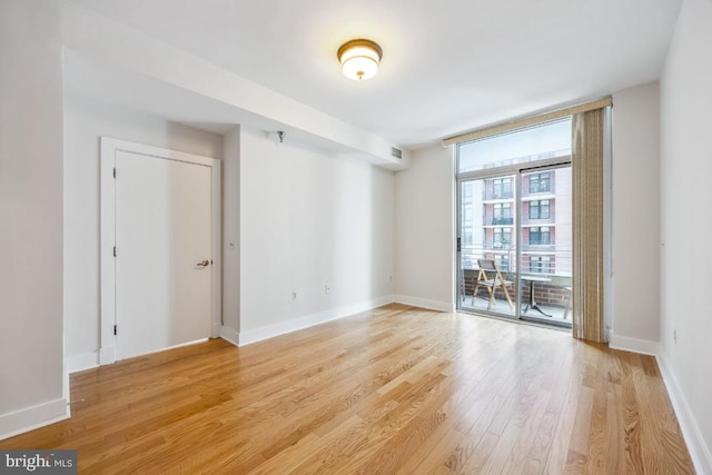 unfurnished room with baseboards, light wood-style flooring, and visible vents