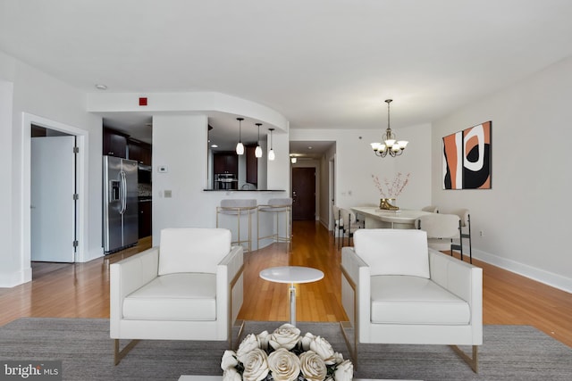 living area with an inviting chandelier, wood finished floors, and baseboards