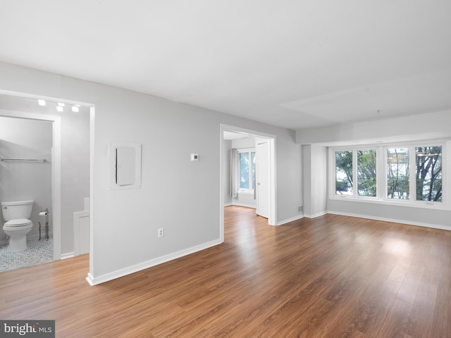 unfurnished living room featuring electric panel and hardwood / wood-style floors