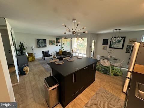 kitchen with light hardwood / wood-style floors, a kitchen island, and stainless steel fridge