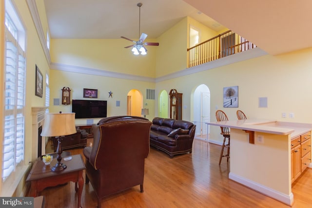 living room with high vaulted ceiling, light wood-type flooring, and ceiling fan