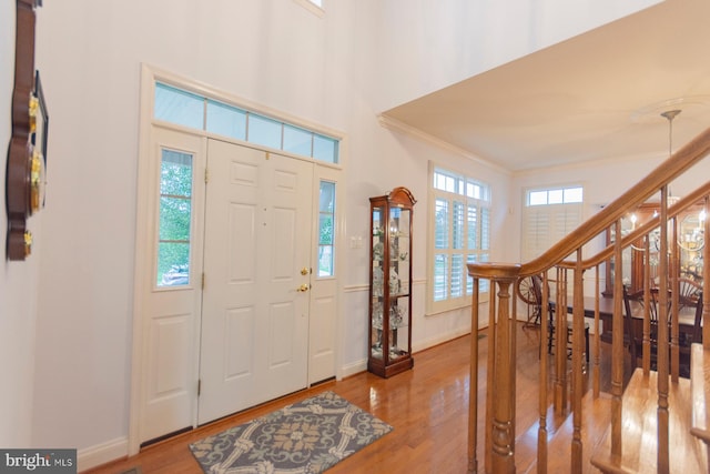 foyer entrance featuring hardwood / wood-style floors and crown molding