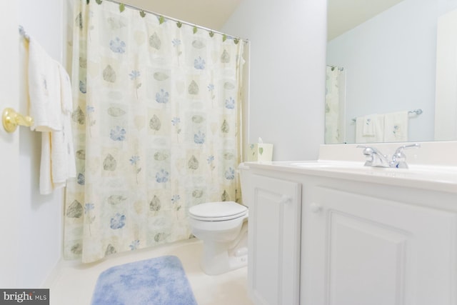 bathroom featuring curtained shower, vanity, and toilet