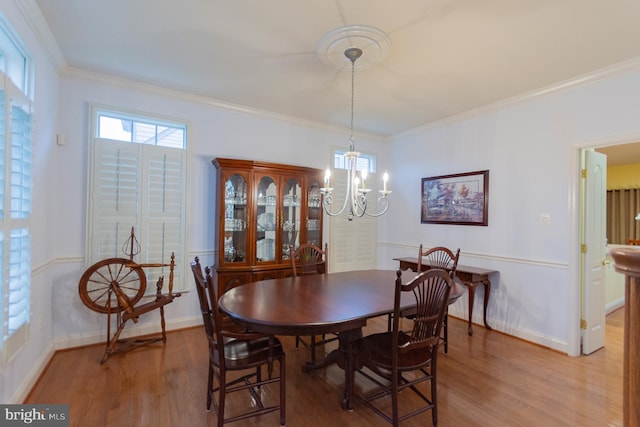 dining room featuring a notable chandelier, crown molding, and hardwood / wood-style floors