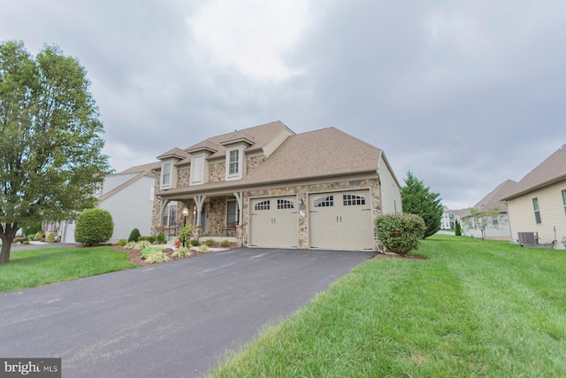 view of front of home featuring central AC unit, a garage, and a front lawn