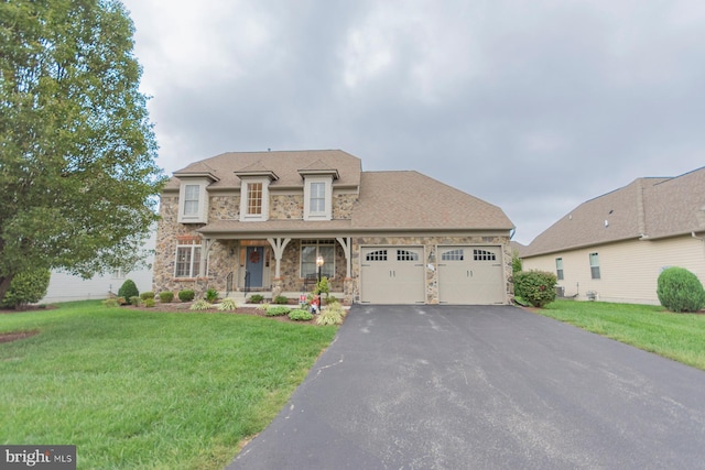 view of front of property with a front yard, a garage, and covered porch