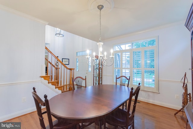 dining room with ornamental molding, a notable chandelier, and hardwood / wood-style floors