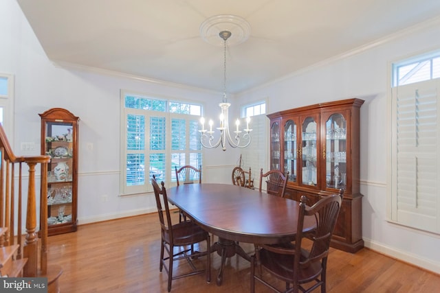 dining space featuring an inviting chandelier, light wood-type flooring, and ornamental molding