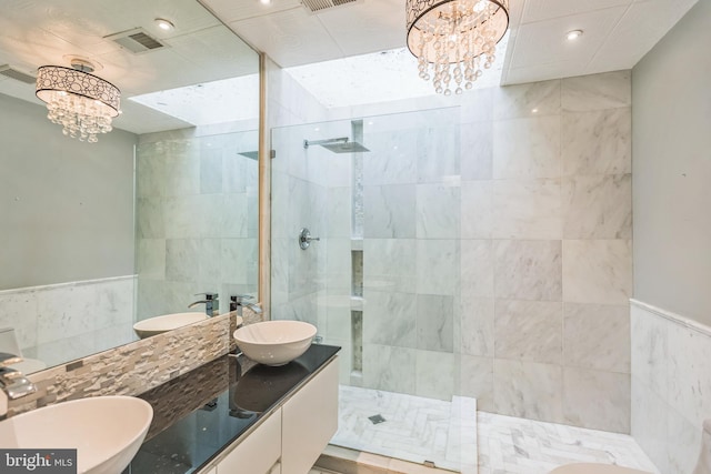 bathroom featuring vanity, tile walls, and tiled shower