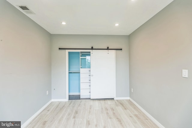 interior space featuring light wood-type flooring and a barn door