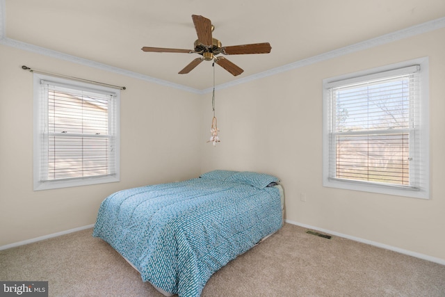 carpeted bedroom featuring ceiling fan and crown molding