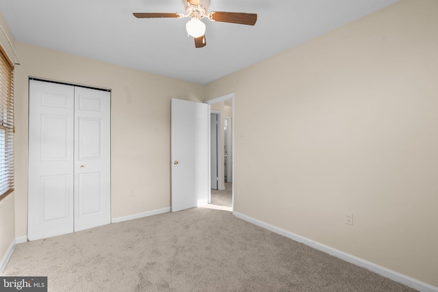 unfurnished bedroom featuring a closet, light colored carpet, and ceiling fan