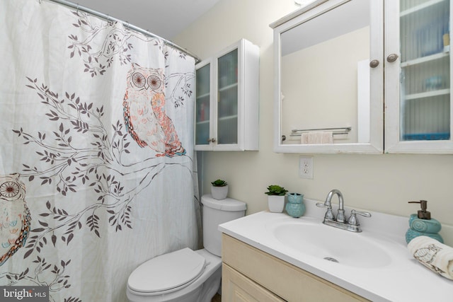 bathroom featuring a shower with curtain, vanity, and toilet