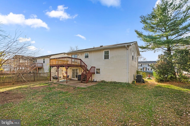 rear view of house with a deck, a lawn, a patio area, and central air condition unit