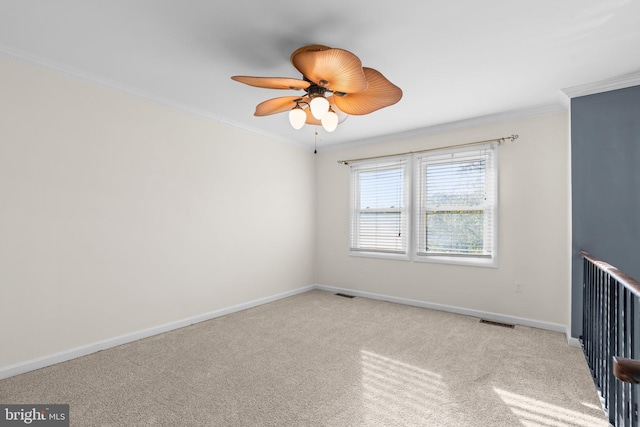 carpeted spare room with crown molding and ceiling fan