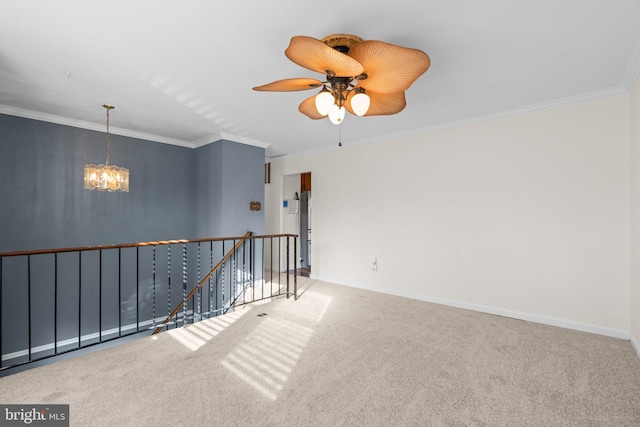 carpeted spare room with ceiling fan with notable chandelier and ornamental molding