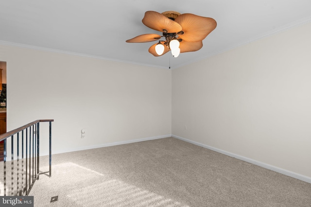 empty room featuring ceiling fan, carpet floors, and ornamental molding