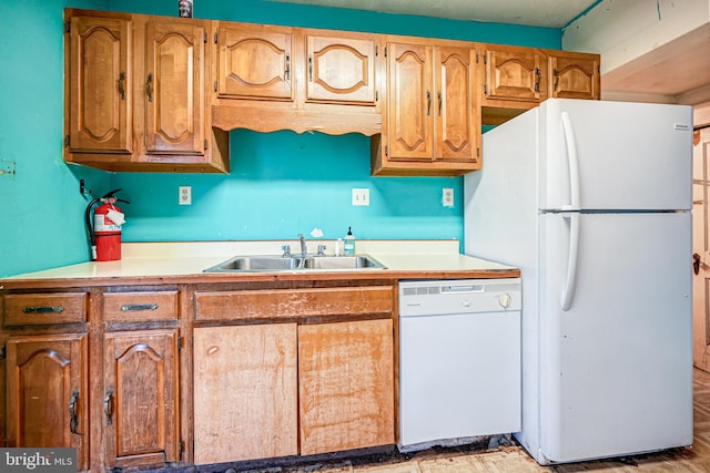 kitchen featuring white appliances, light hardwood / wood-style floors, and sink