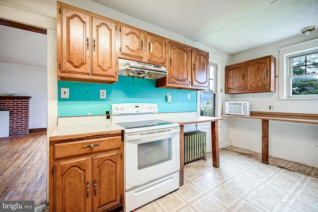 kitchen with radiator, a wall mounted AC, and white range with electric stovetop