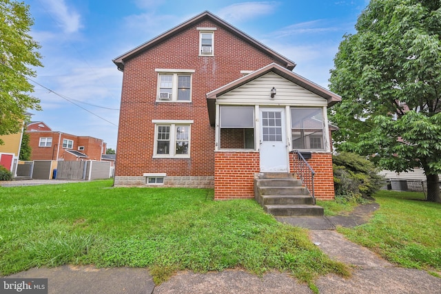 view of property with a sunroom and a front lawn